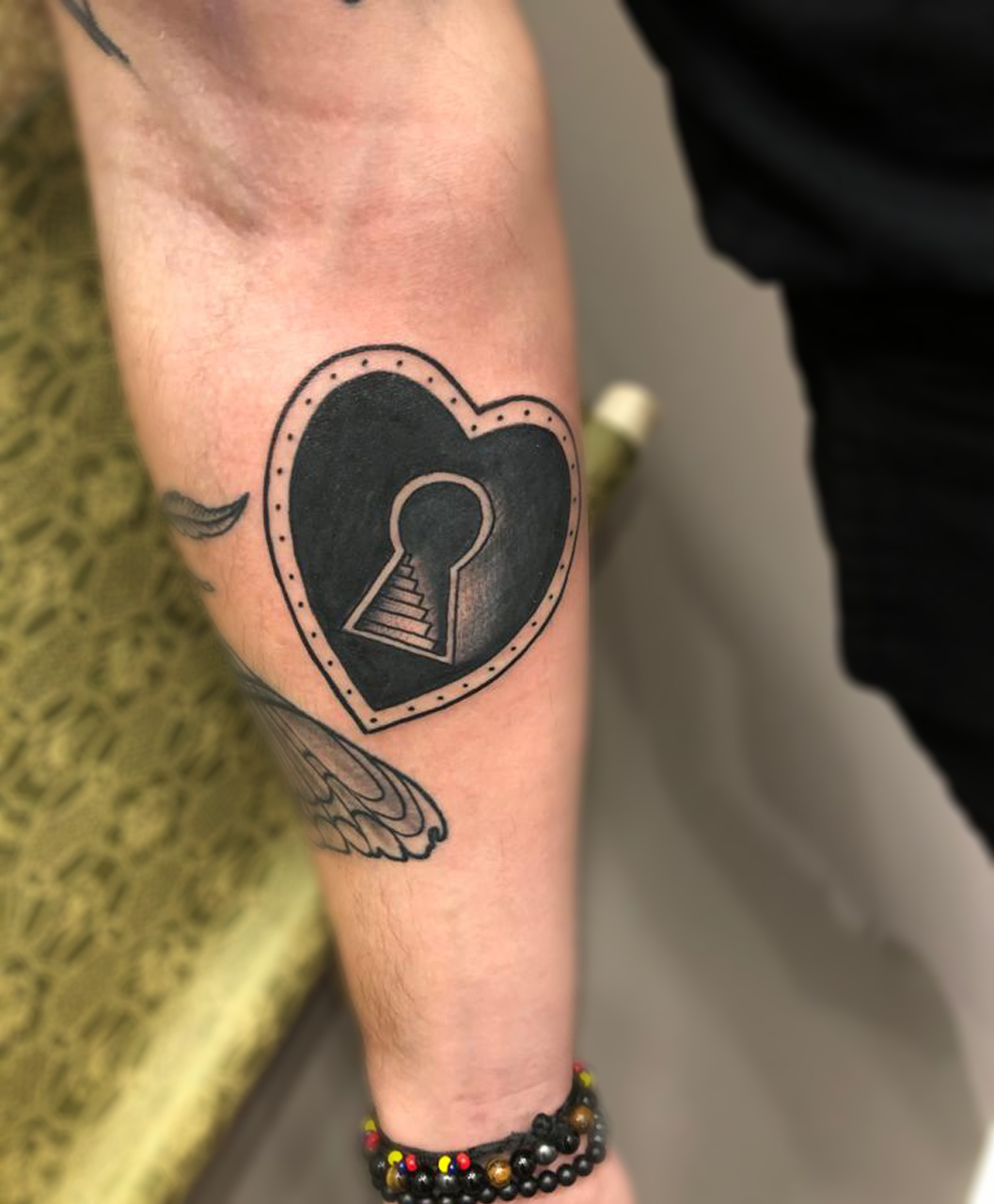 Tatouage coeur avant-bras noir et gris